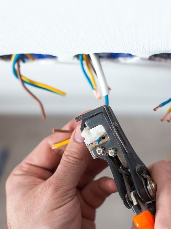 An electrician working on wiring for some lights.