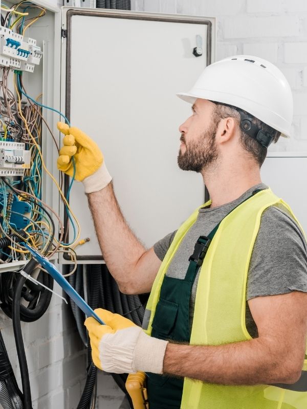 An electrician is working on an electrical panel.