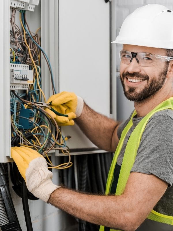 An electrician is working on an electrical panel.