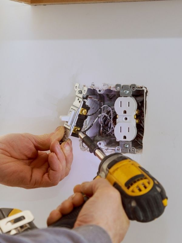 An electrician is installing an outlet in a new residential build. 