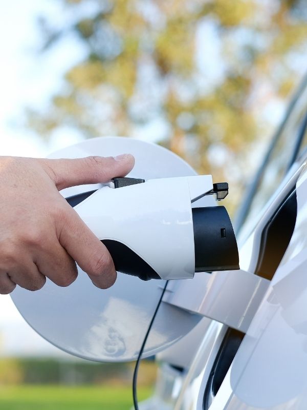 A person plugging in their electric vehicle. 